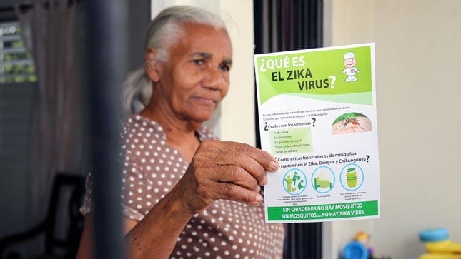 Woman holding "What is the Zika virus?" handout