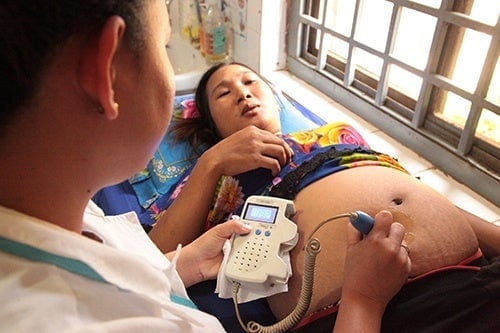 Midwife Sou Sreymech checks over a pregnant woman at the Oyadav district health center in Rattanakiri, Cambodia. © UNFPA/ Matthew Taylor