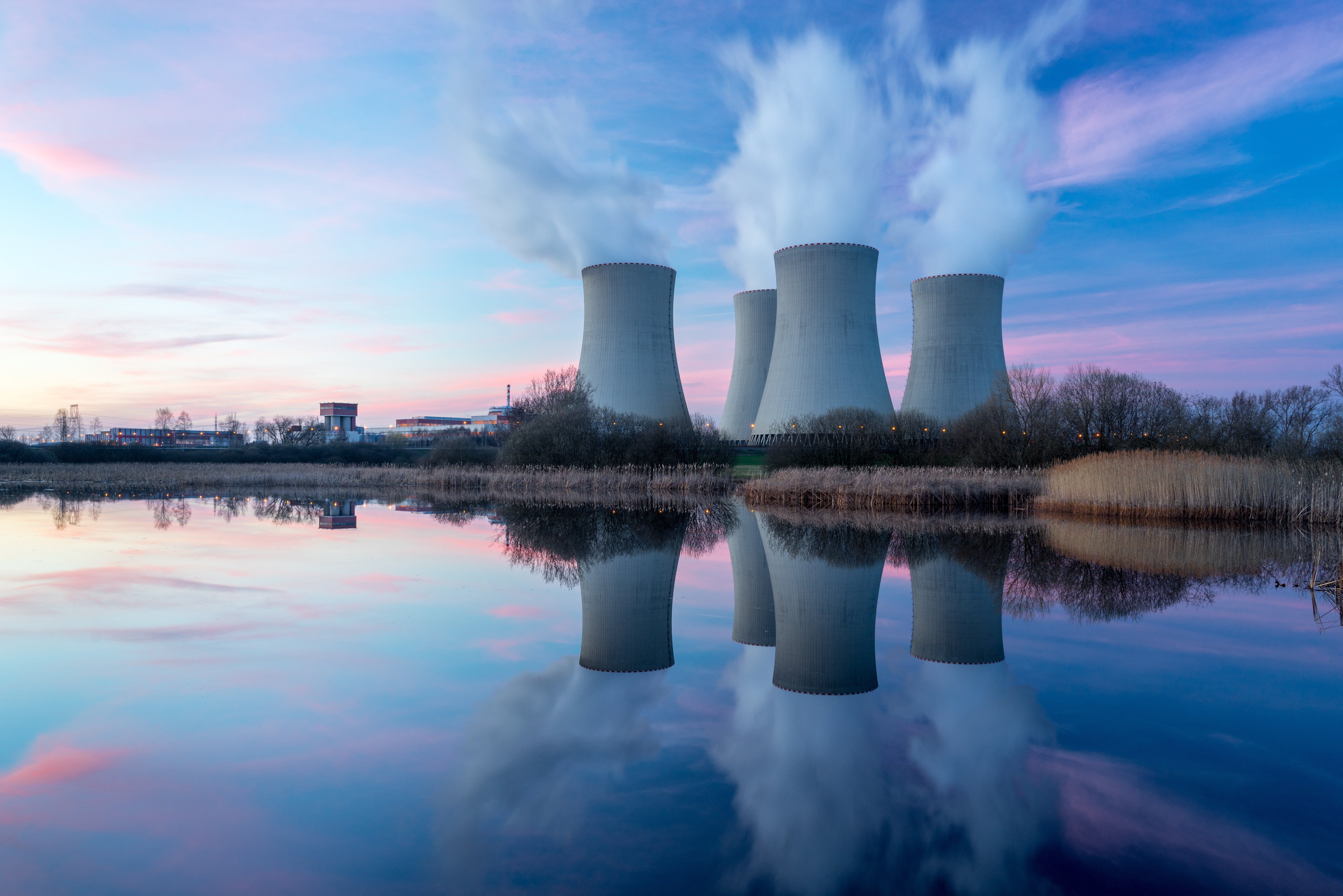 A nuclear power plant located next to a lake with four thermal power stations.