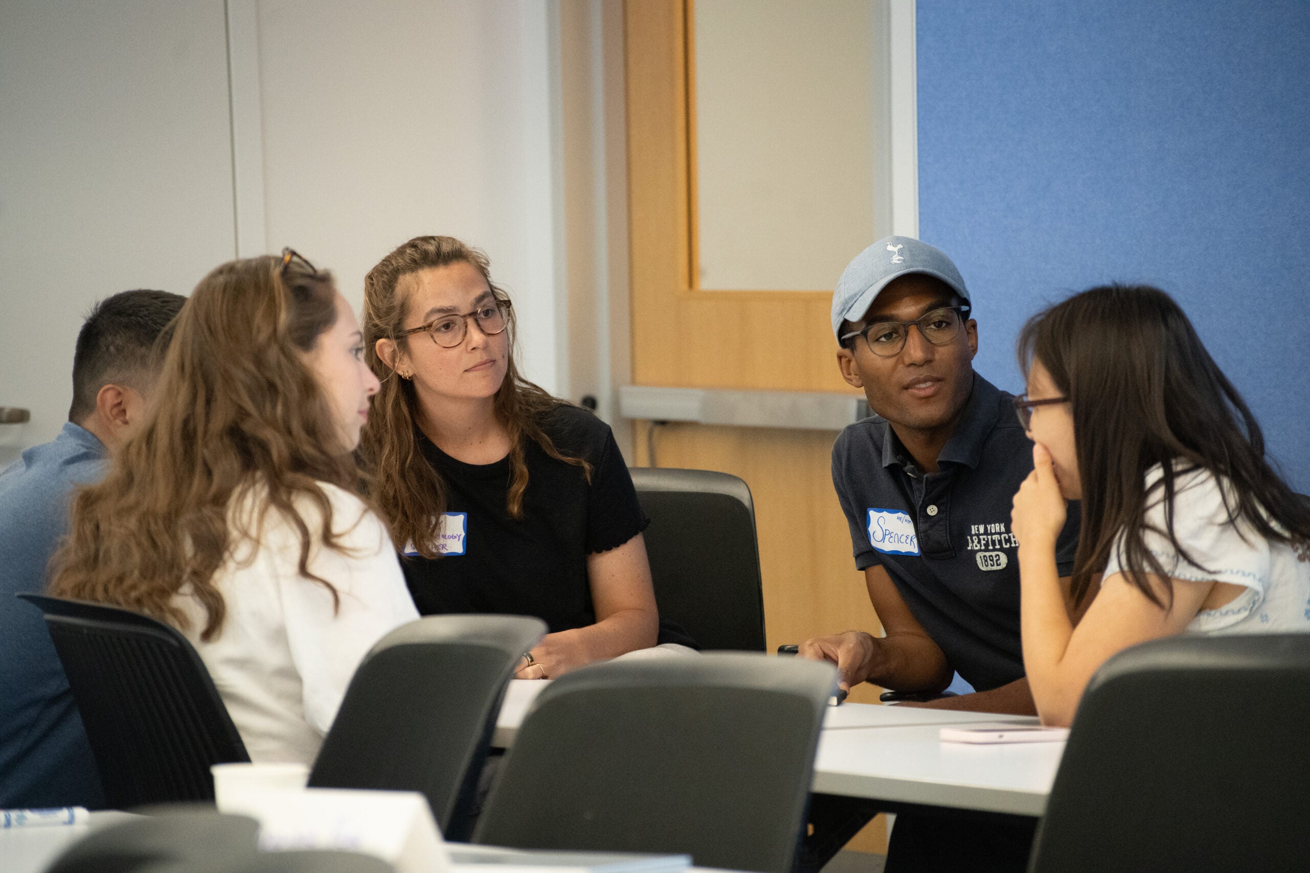 PHS students sitting together at a table during orientation, engaged in discussion.
