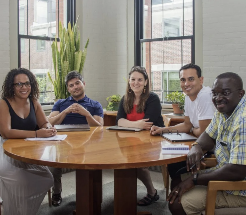 Fellows seated around a table, ready to start a workshop's activity