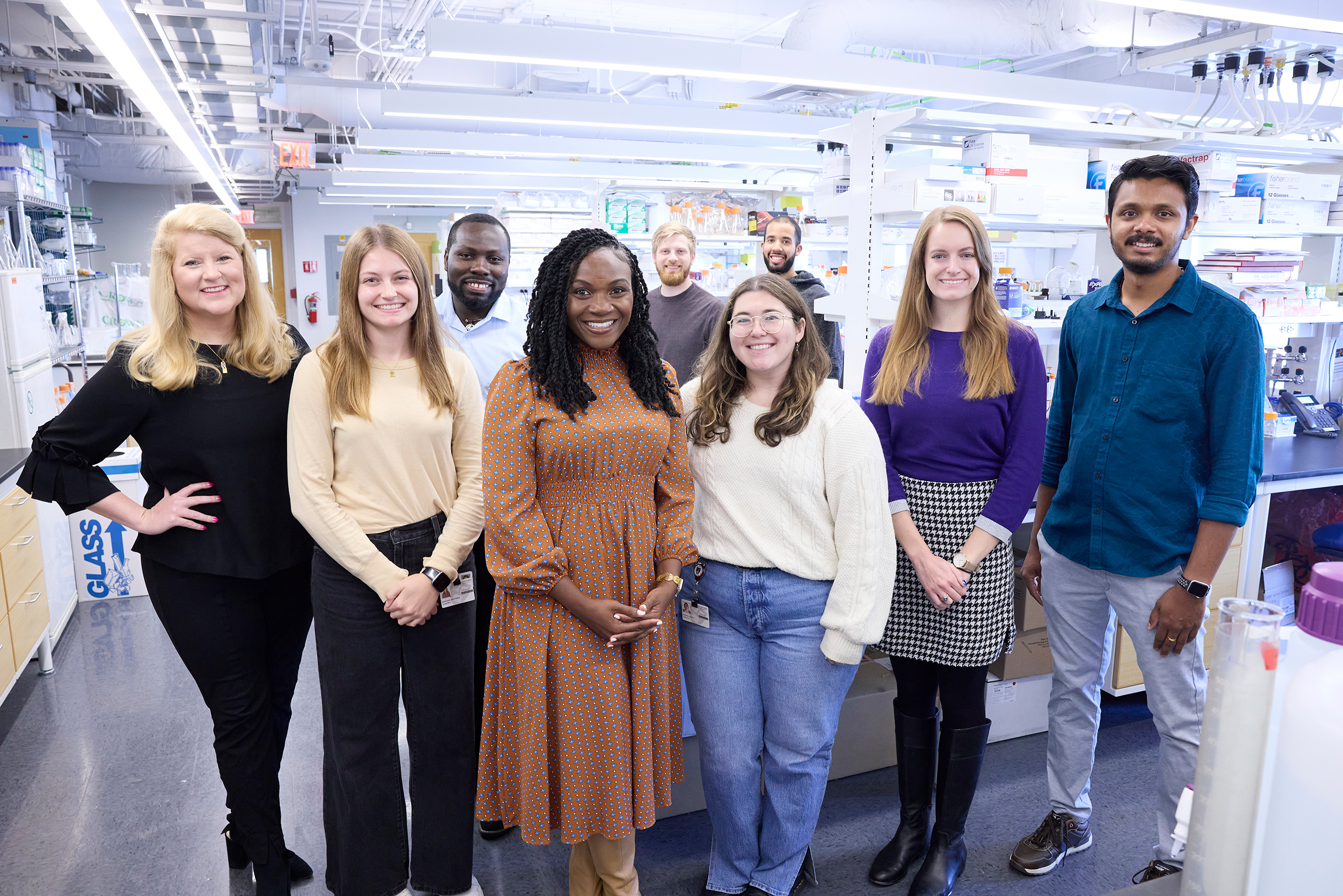 Corbett Lab group photo. Kizzmekia Corbett in the middle, surrounded by her team in the lab at the Harvard T. H. Chan School of Public Health