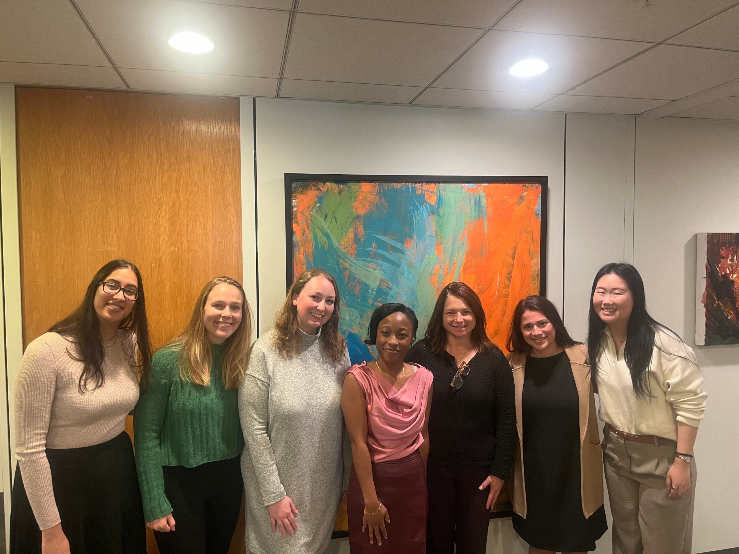 Group gathered in a hallway in front of a painting.