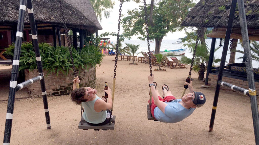 Rob and Kelsey in Malawi playing on swings, in a moment of relax.