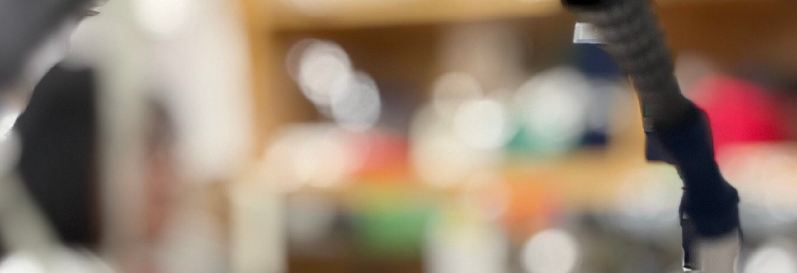 A abstract look through a bench to the researchers working in a blur in the background