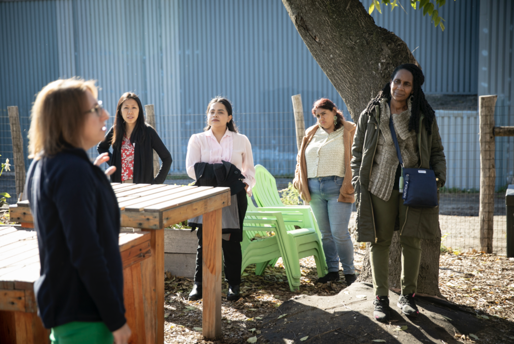 Fellows attentively listening to a community member during a site visit in Chelsea, MA.