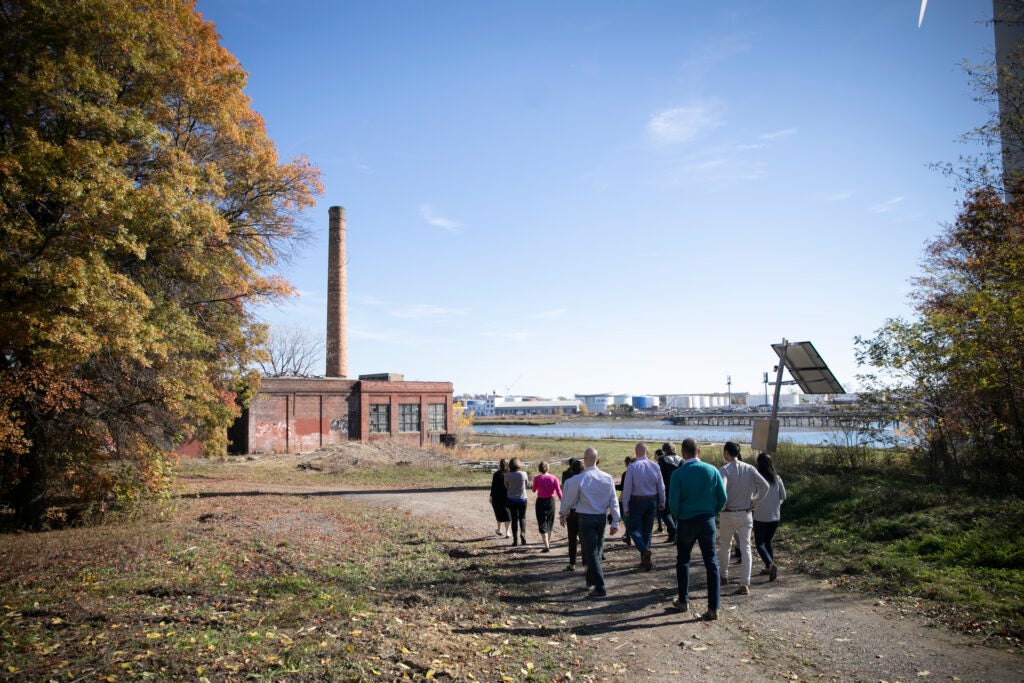 A group of Fellows walking toward an empty factory by Chelsea Creek in Chelsea as part of their site visit