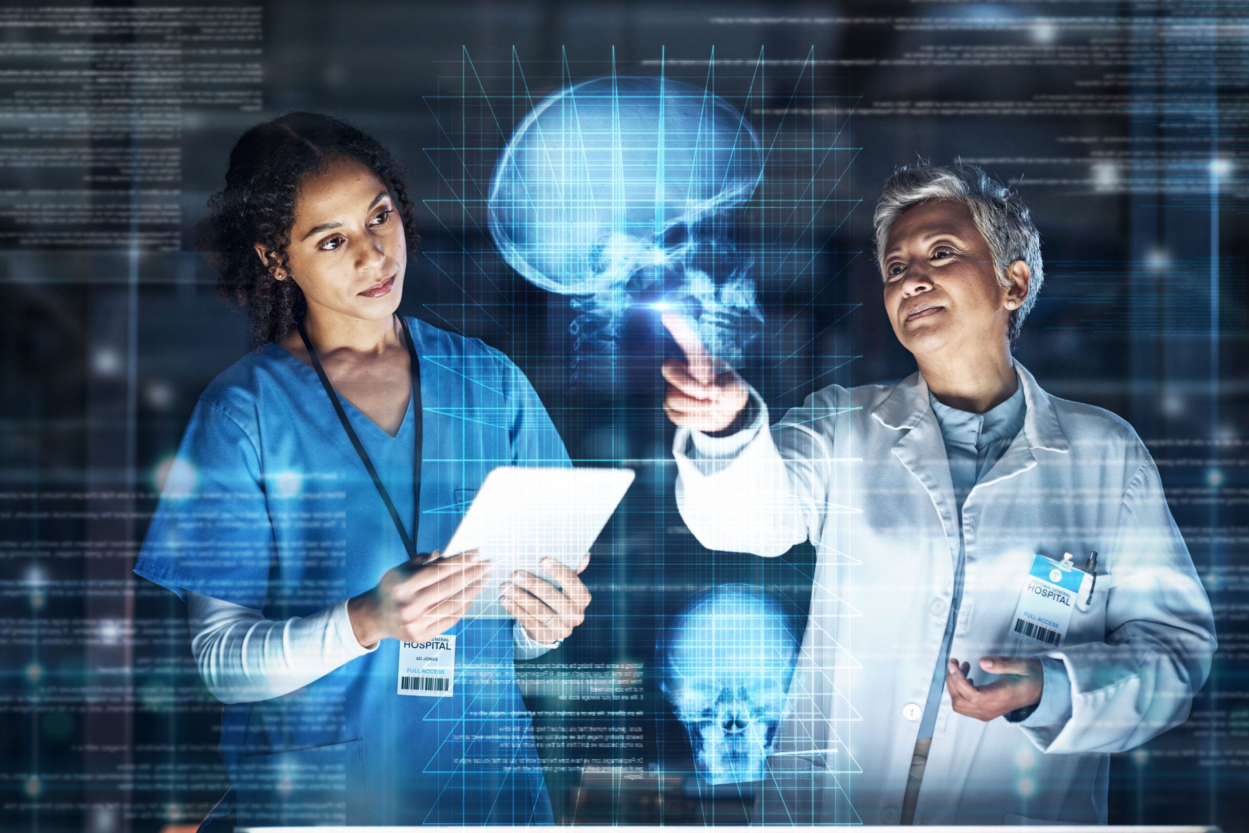 A doctor and nurse holding a tablet and looking at a holographic image of a brain