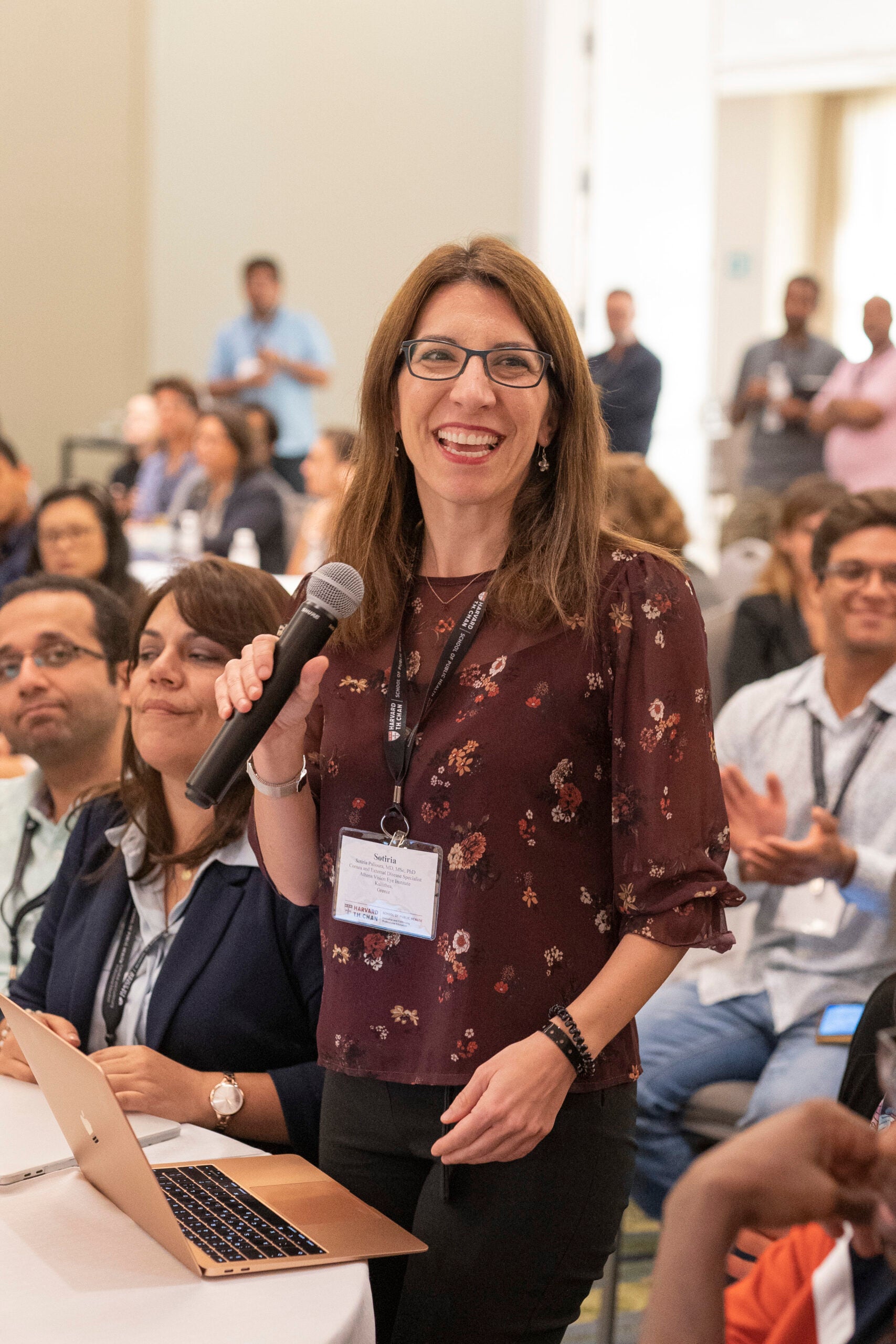 Smiling PPCR participant speaking as an attendee in a crowd