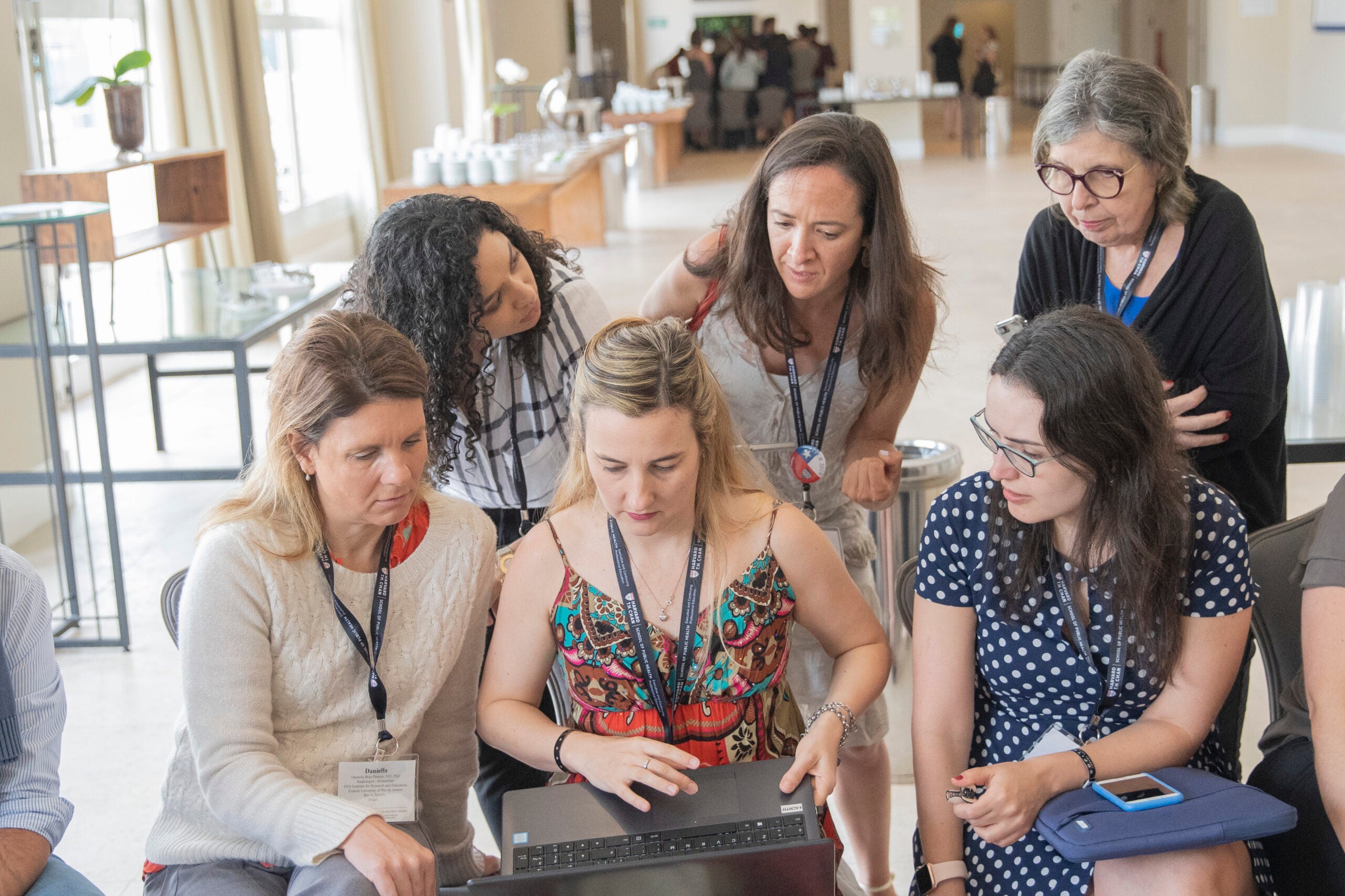 A group of women huddled around a laptop
