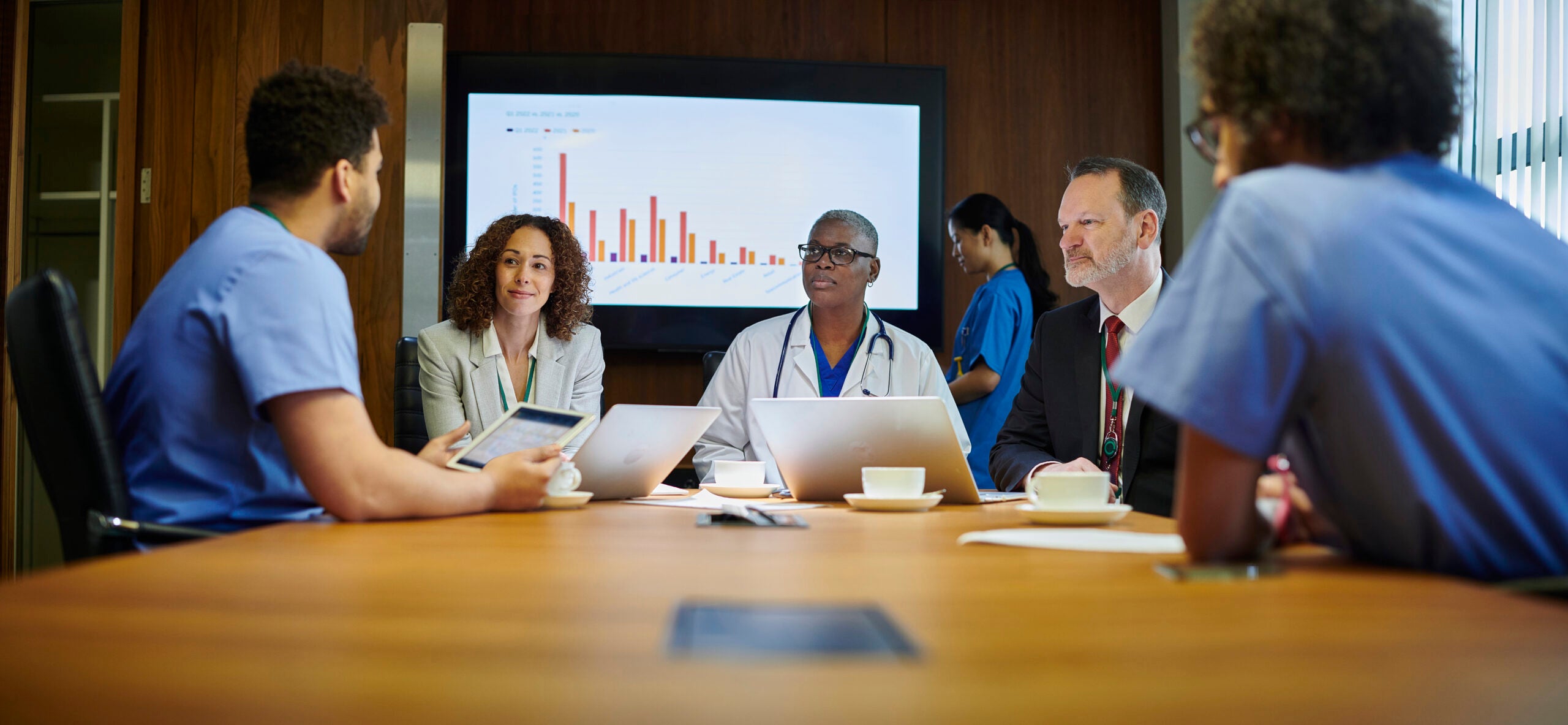 Group of medical professionals and executives in a meeting in a board room