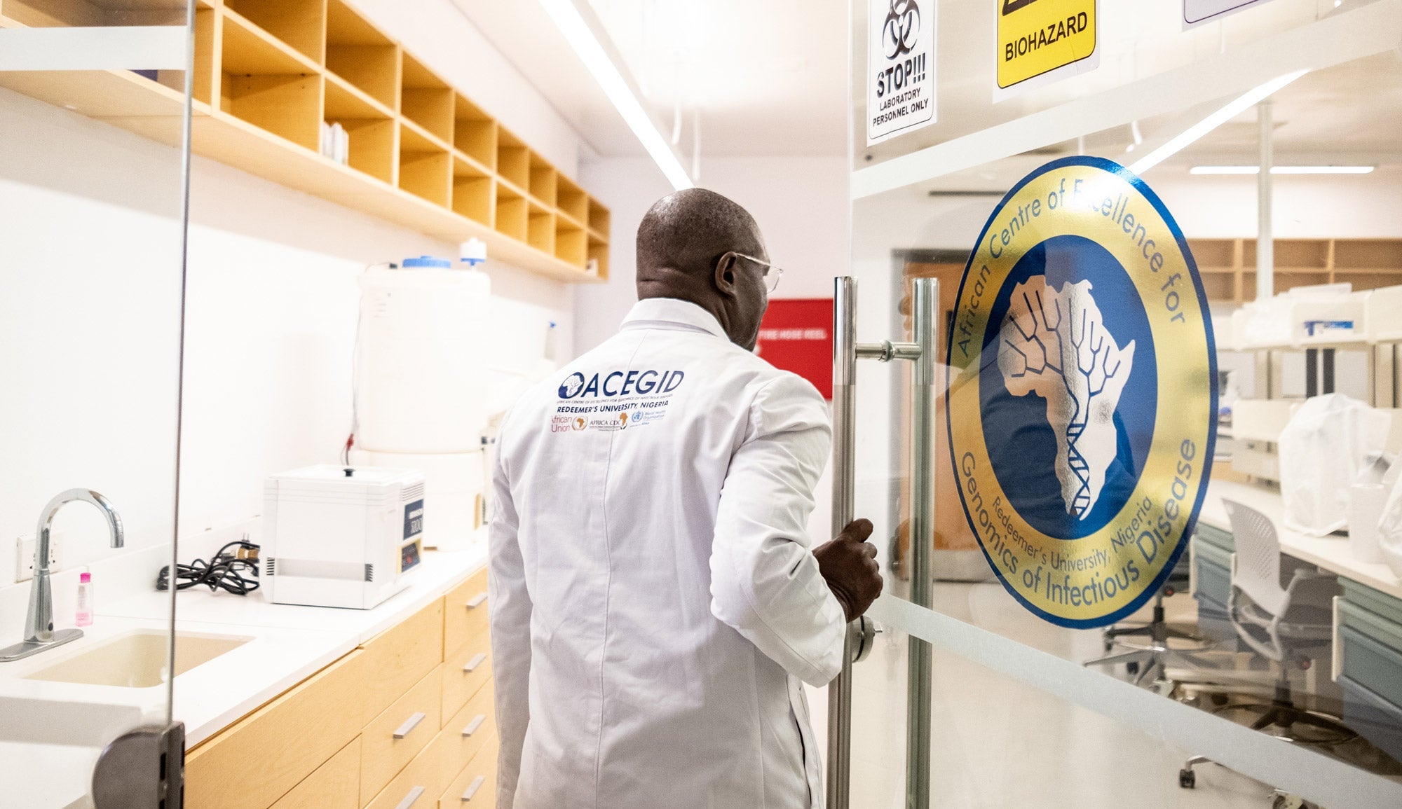 Dr. Christian Happi opening the door to a lab at the African Centre of Excellence for Genomics of Infectious Diseases.