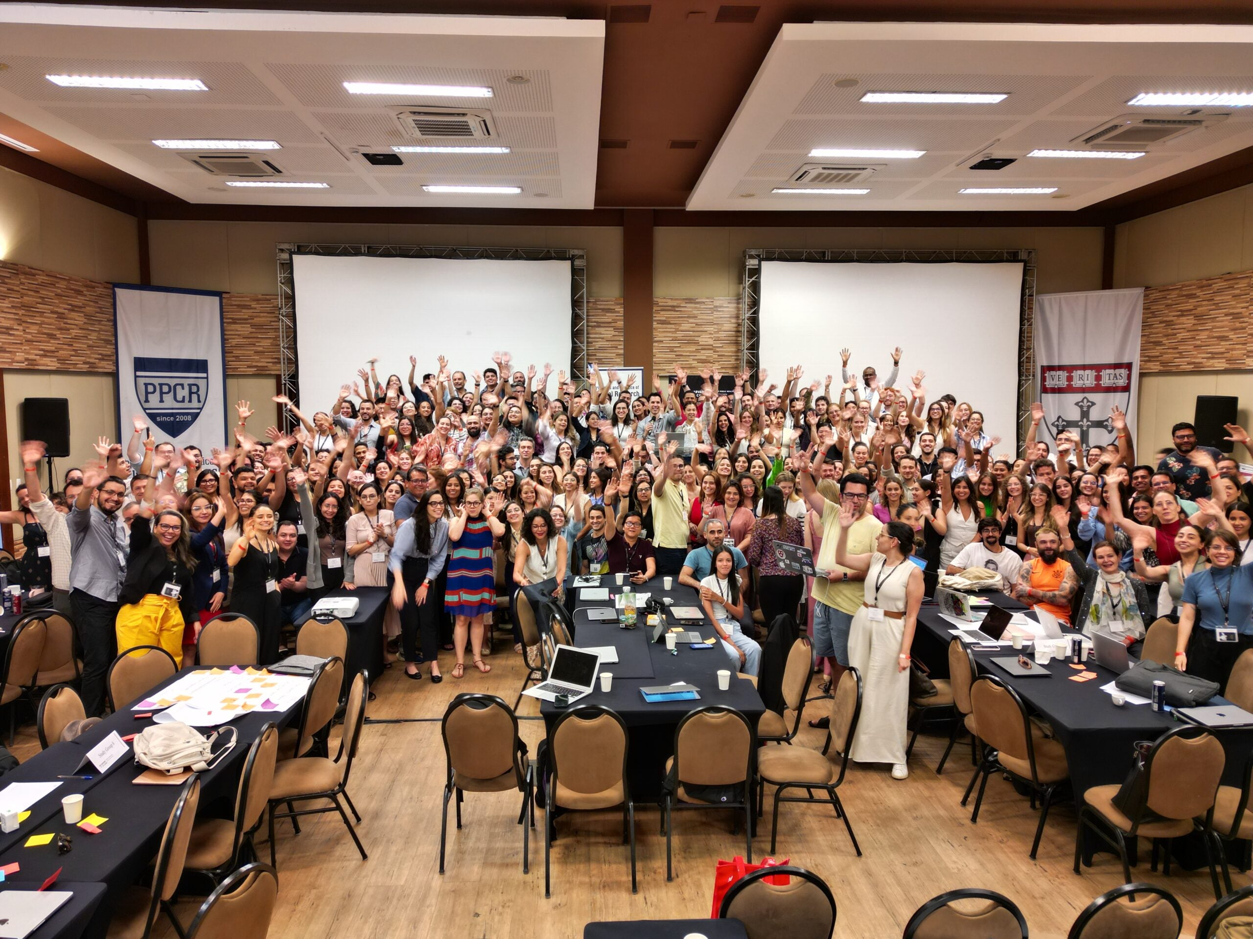 Group photo of PPCR24 participants standing in a large conference room