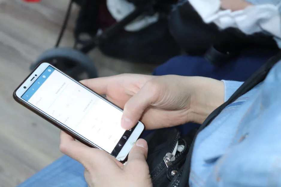 A health systems innovation lab student olding a phone