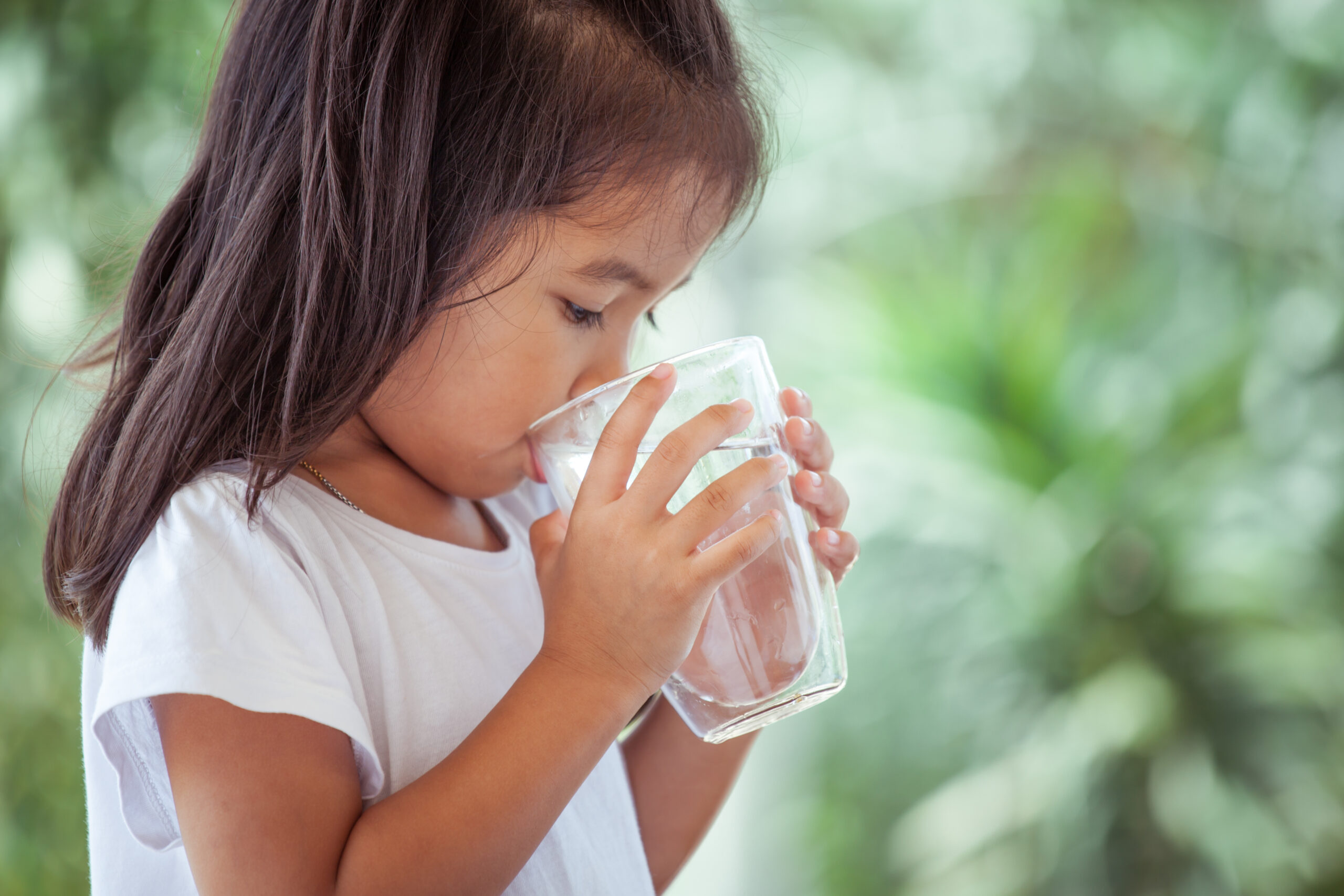 Young girl drinking a glass of water