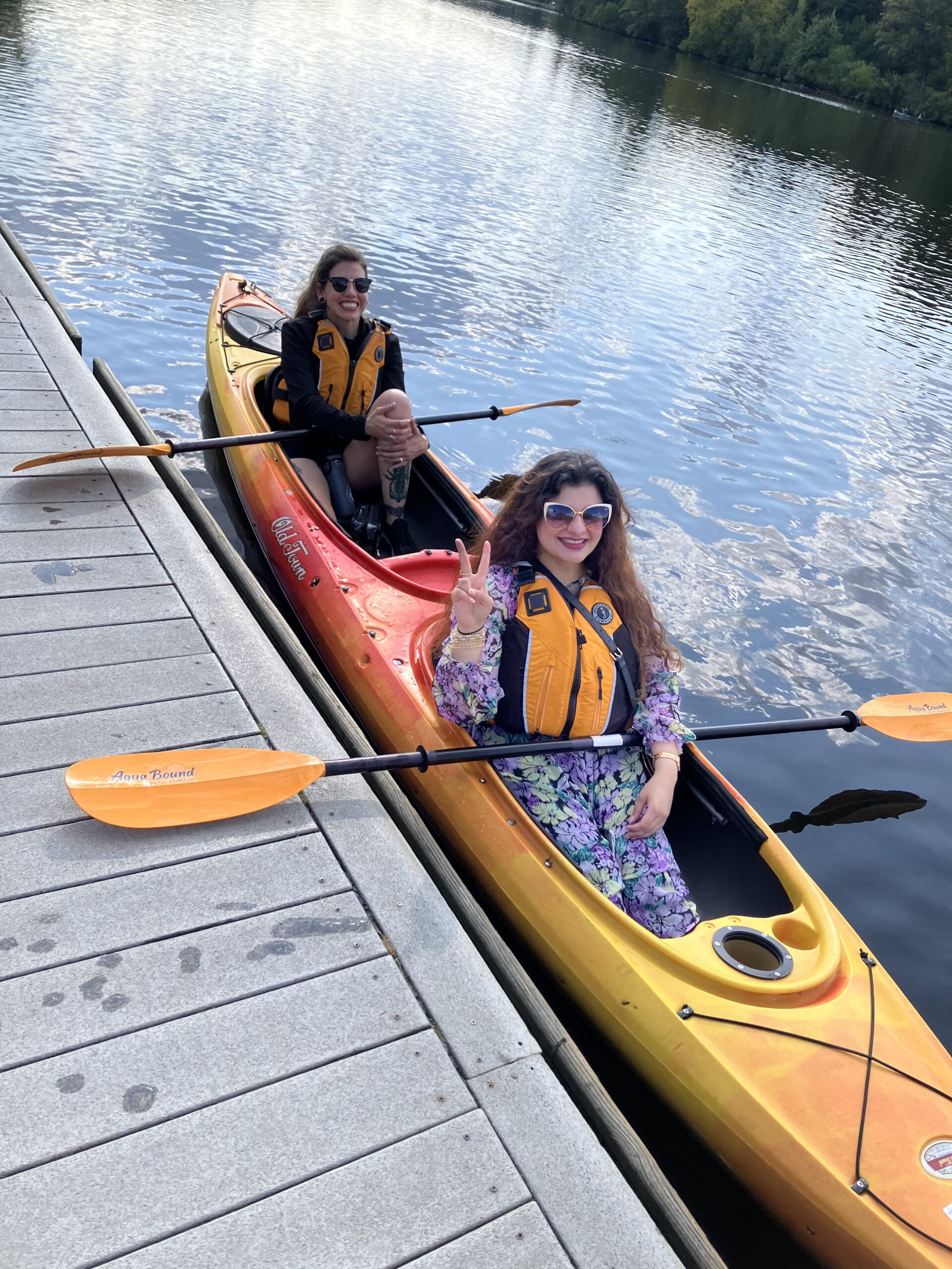 Two women in a yellow kayak on the river.