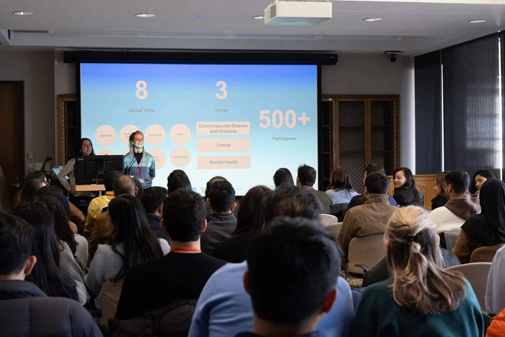 Nour Sharara (left) and Caroline Bulstra of the Health Systems Innovation Lab greet hackathon participants