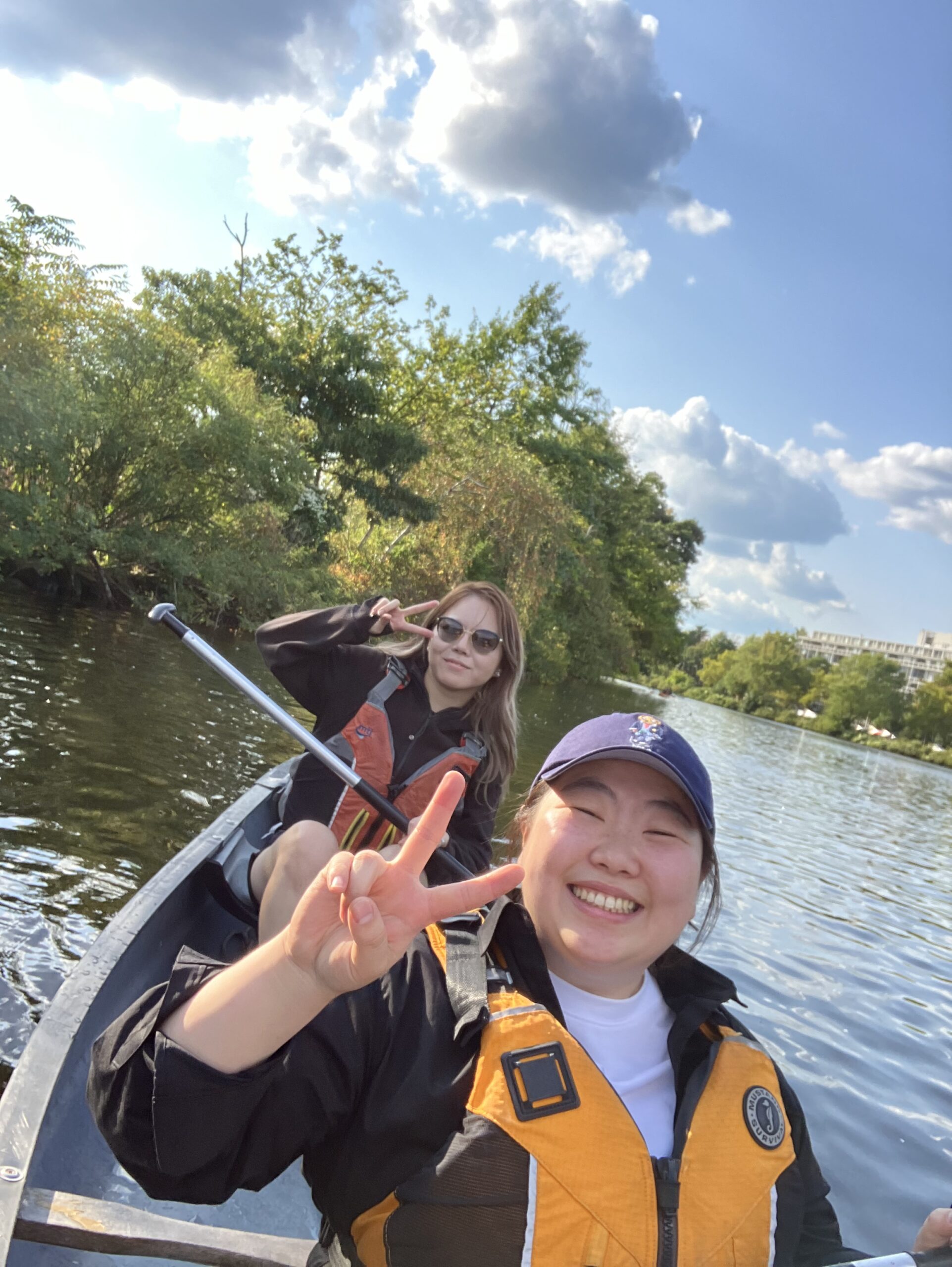 Two women in a yellow kayak on the river.