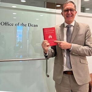 Dean Andrea Baccarelli holds a copy of the Book "Phantom Plague"