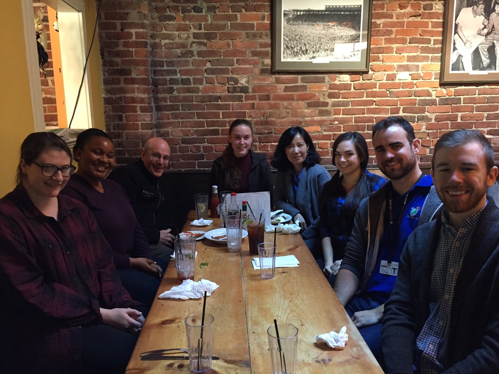 A group of students and researchers at a table in a restaurant.