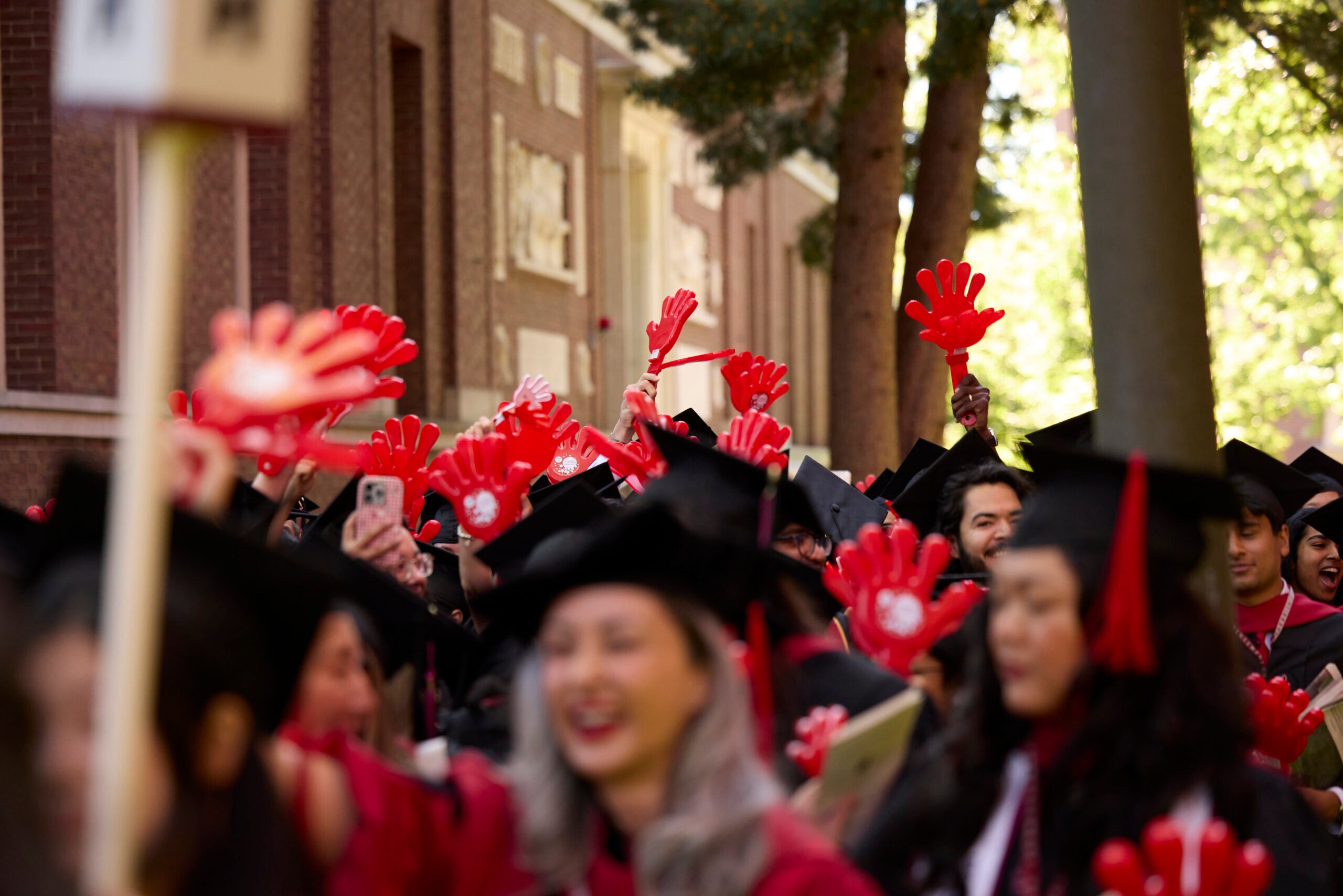 Graduating students wave Harvard Chan School clappers at Commencement.