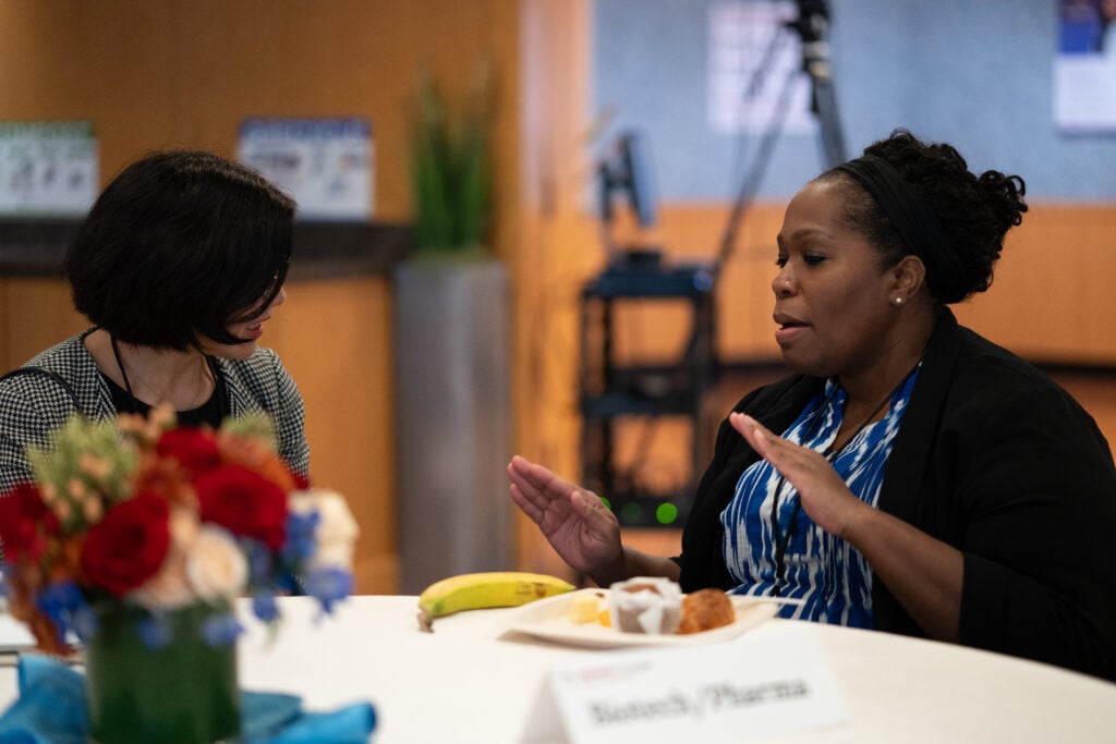 Two women seated at a table engaged in deep discussion. 