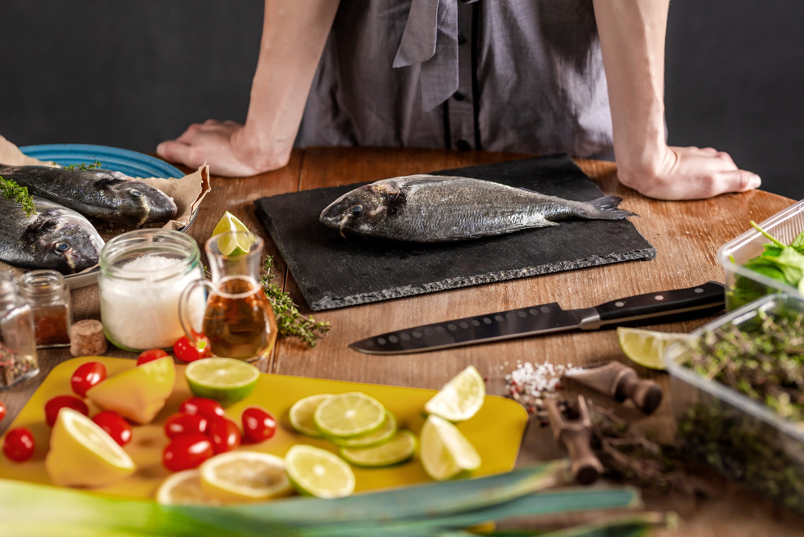 chef in a kitchen preparing fresh raw dorado fish