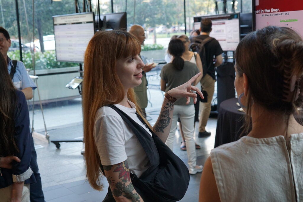 Trainees discuss posters during 20th Anniversary poster session