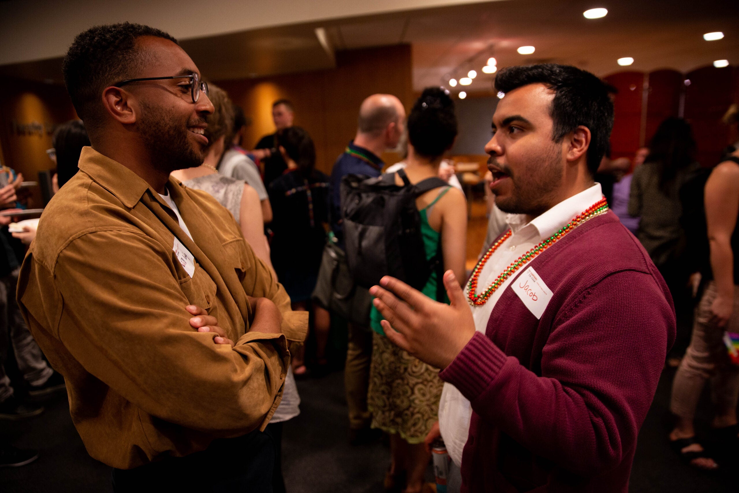 Students talking to one another in a crowded room.