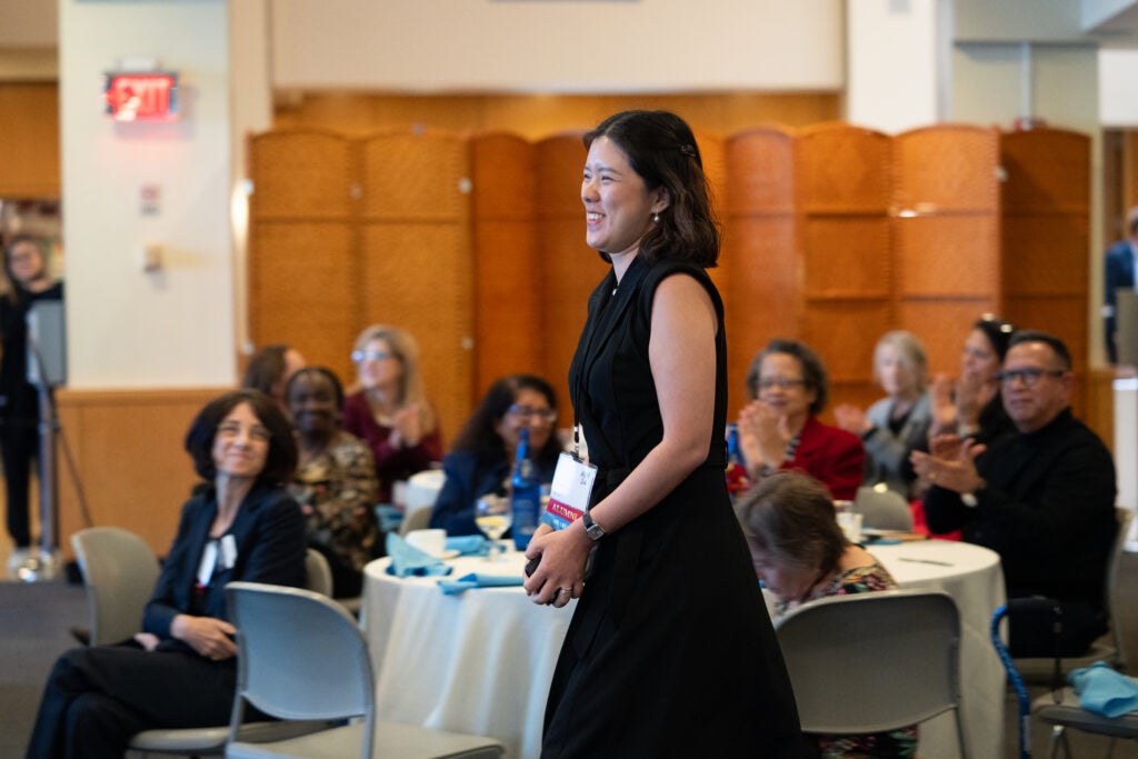 Beverly Lorraine Ho, MPH ’15, approaches the stage to receive an award at Alumni Weekend 2024. 