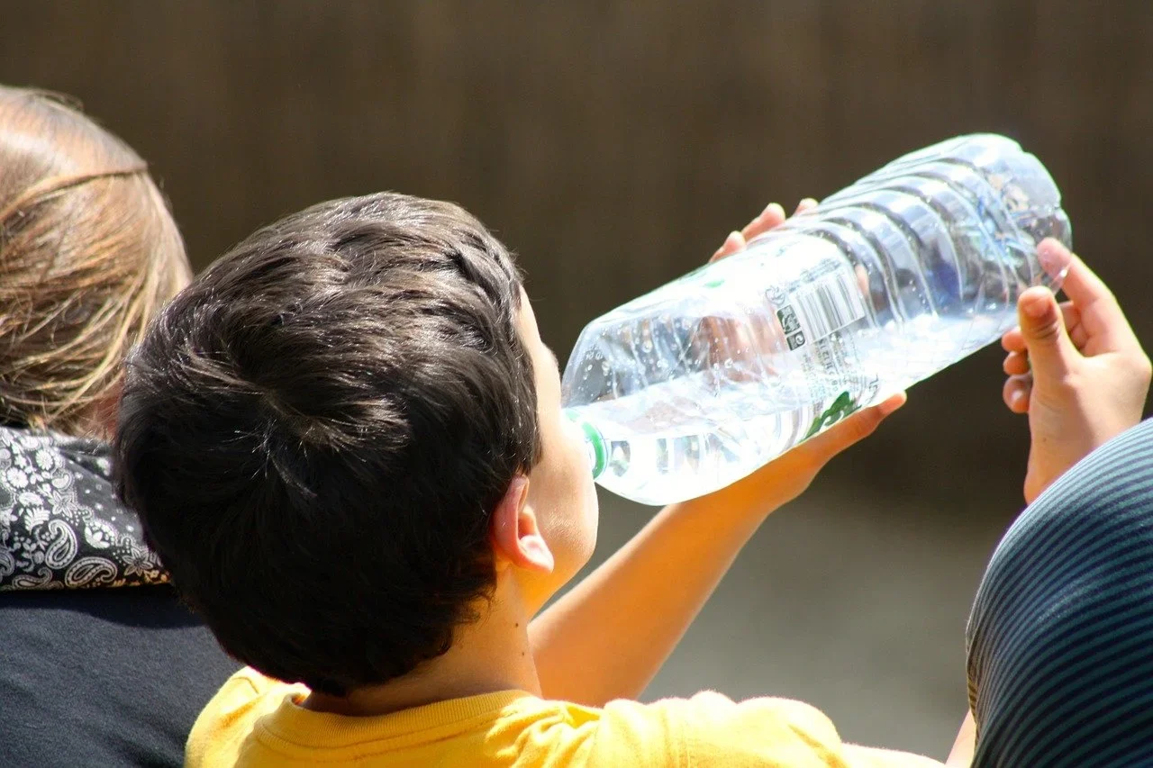 Boy drinking water on a hot day