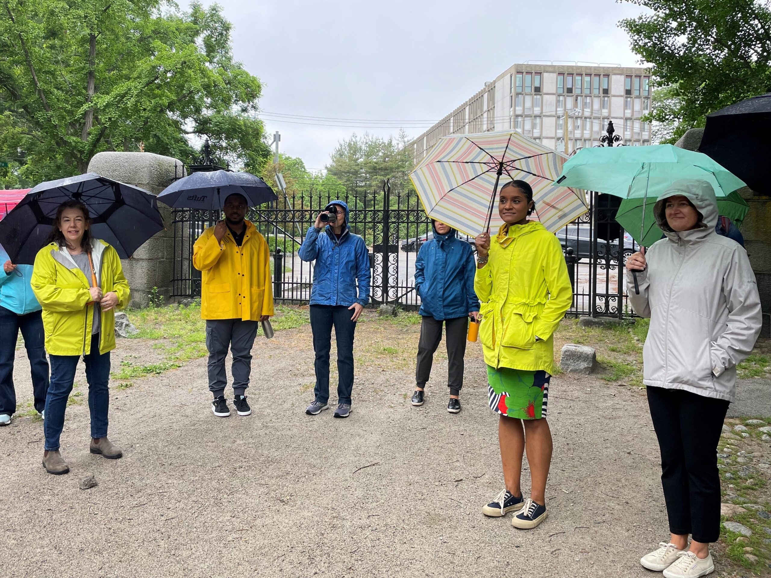 Fellows holding umbrellas, gathered together and ready to begin a walk in the Boston Arboretum