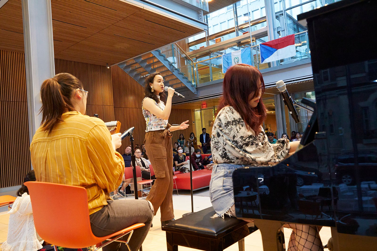 Students singing and playing piano on stage.