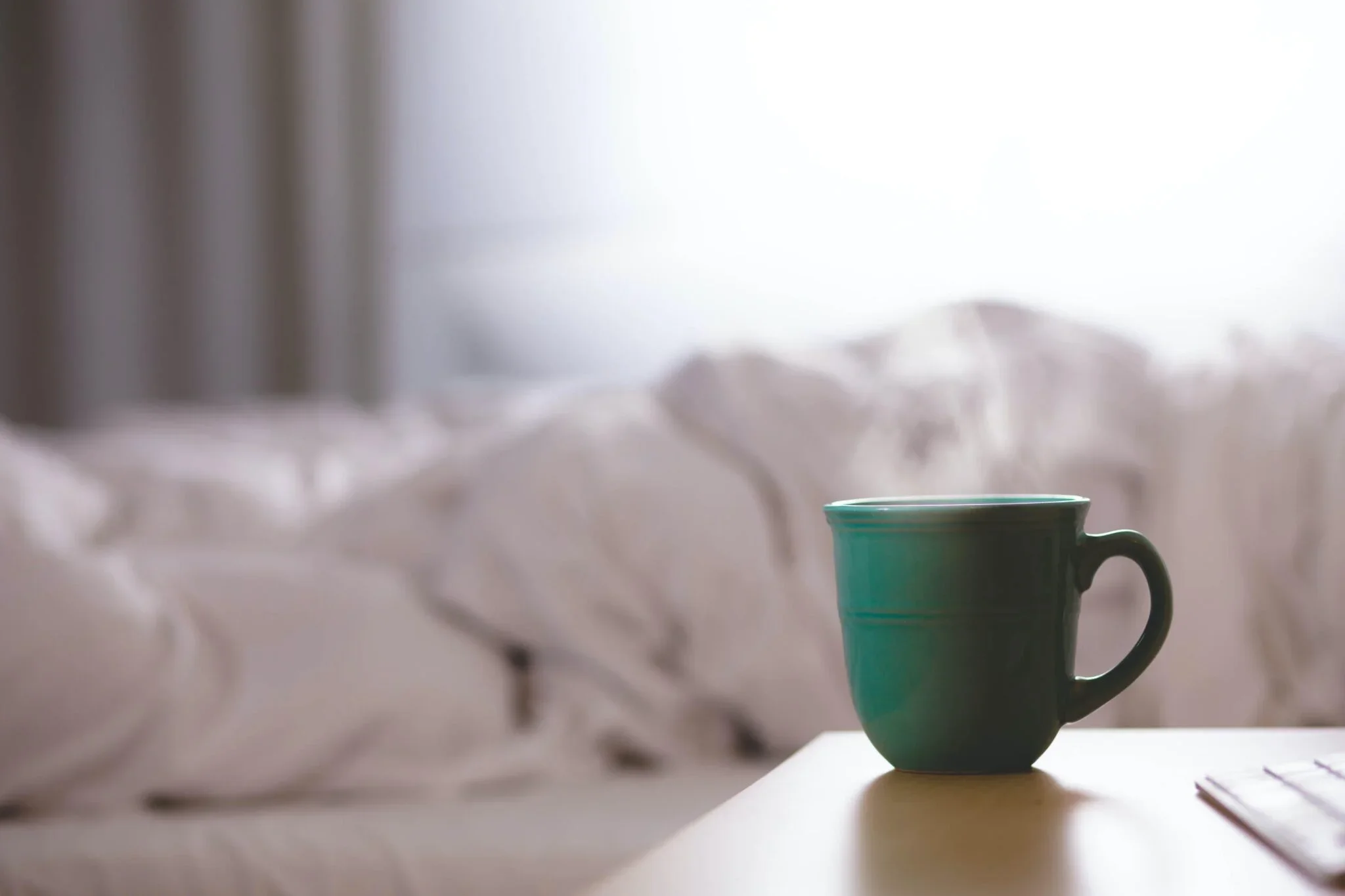 Cup of tea next to a bed