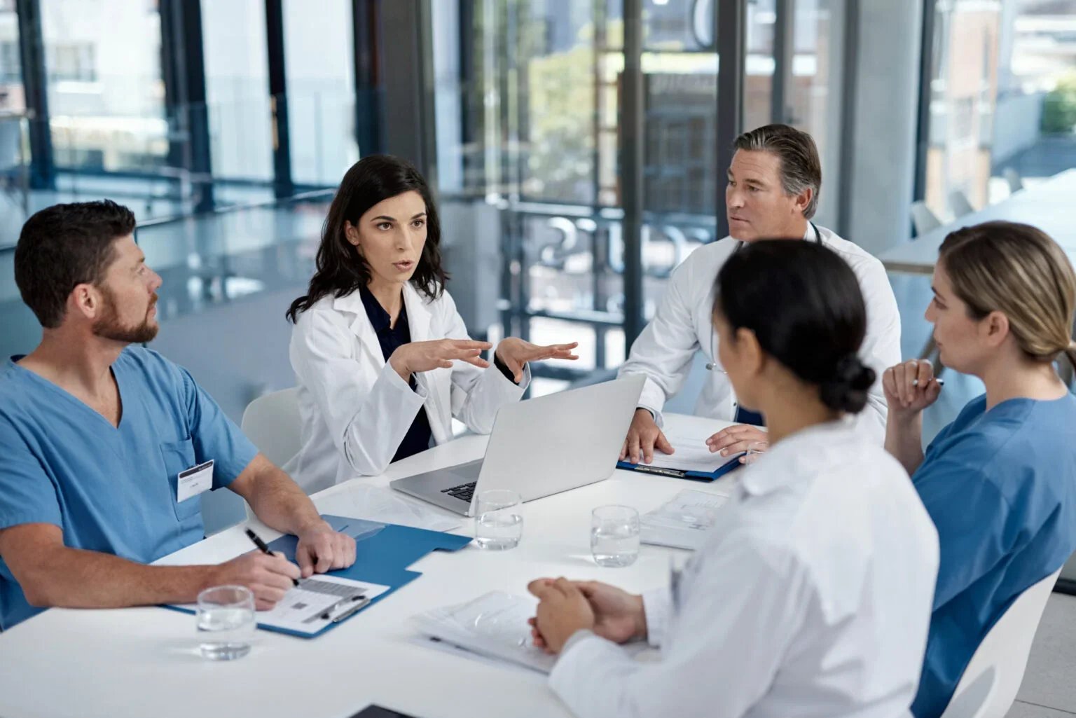 team of medical professionals are talking at a table