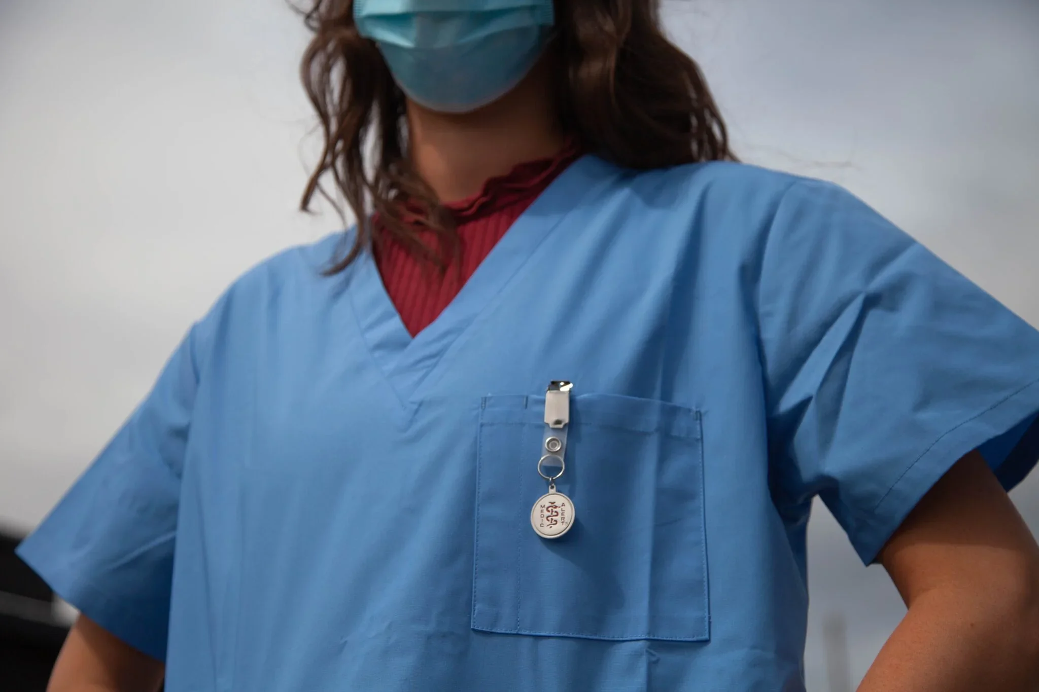 Woman wearing scrubs and a mask