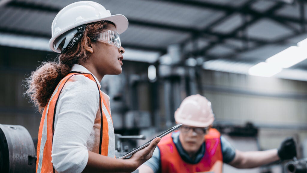 Female industrial engineer wearing a white helmet while standing