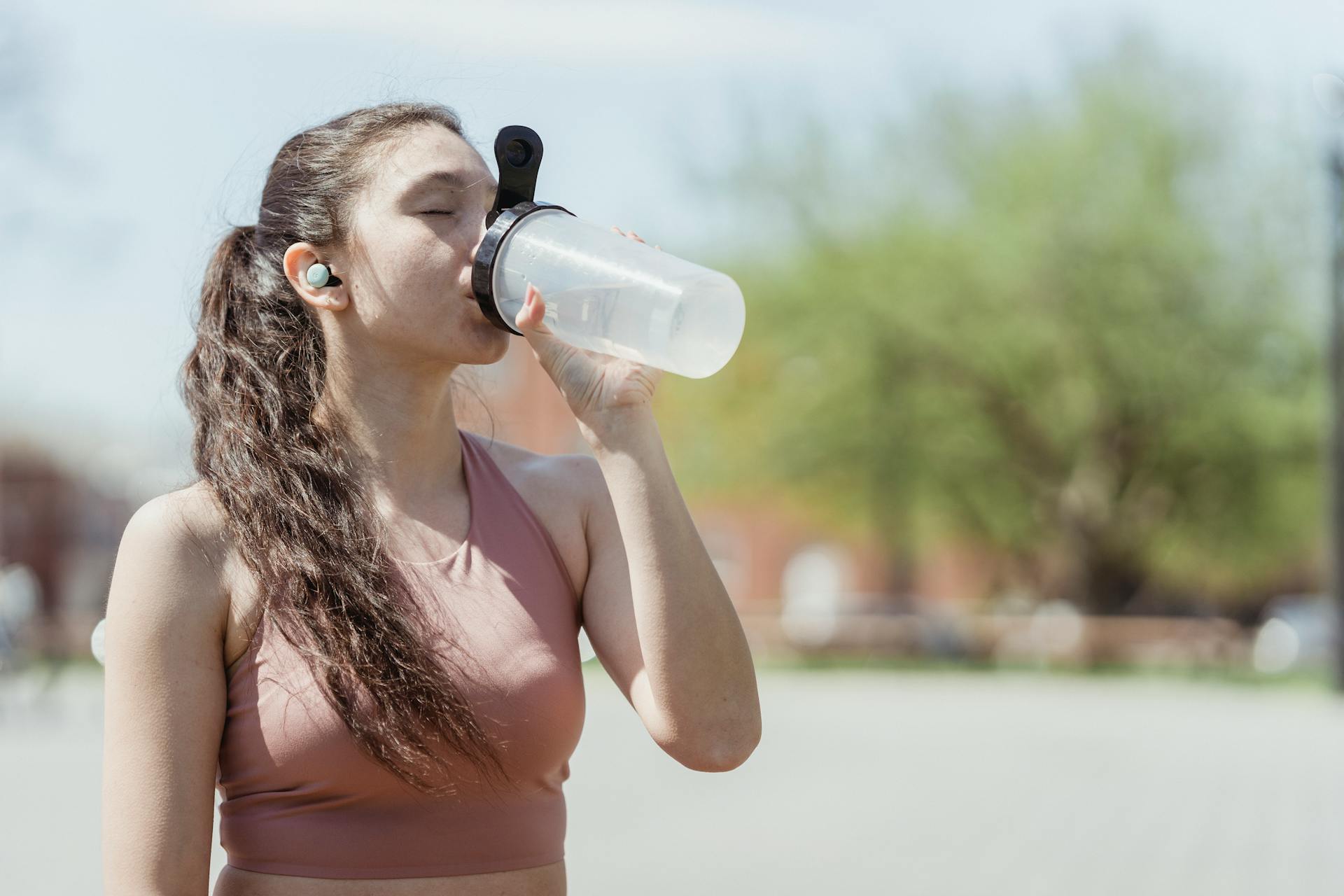Woman in Sportswear Drinking Water from Bottle