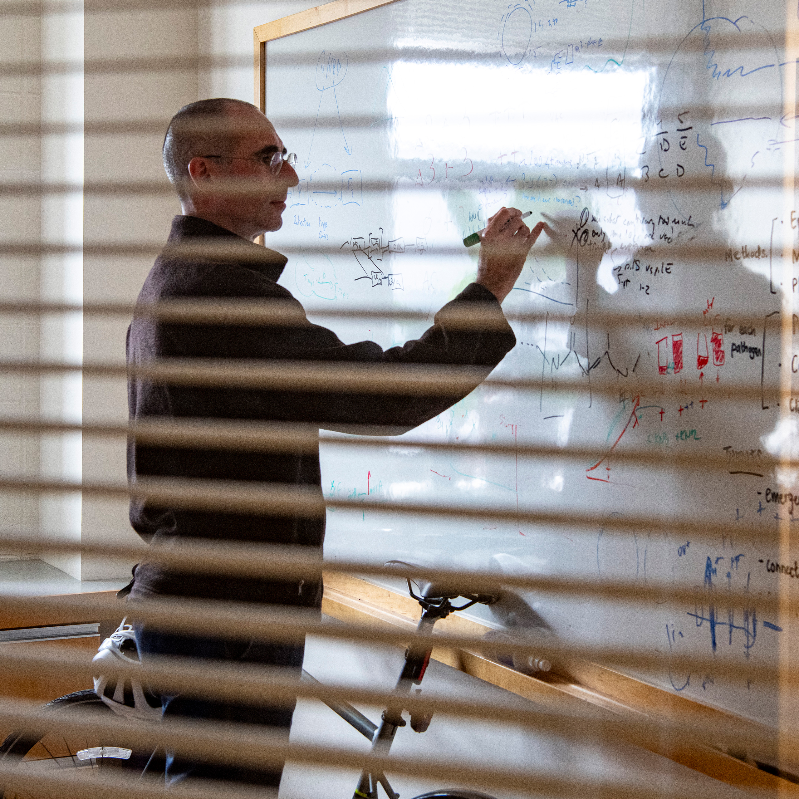 Yonatan Grad writing on the board in his office