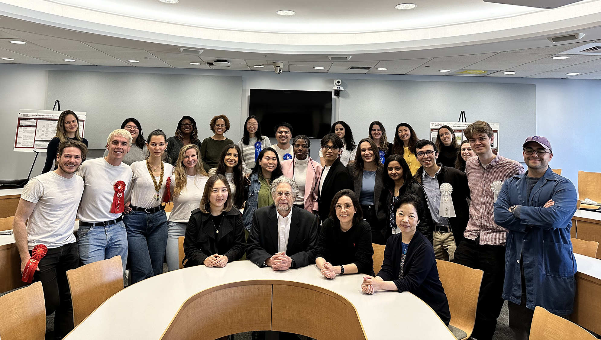 Students and faculty members pose in a classroom.