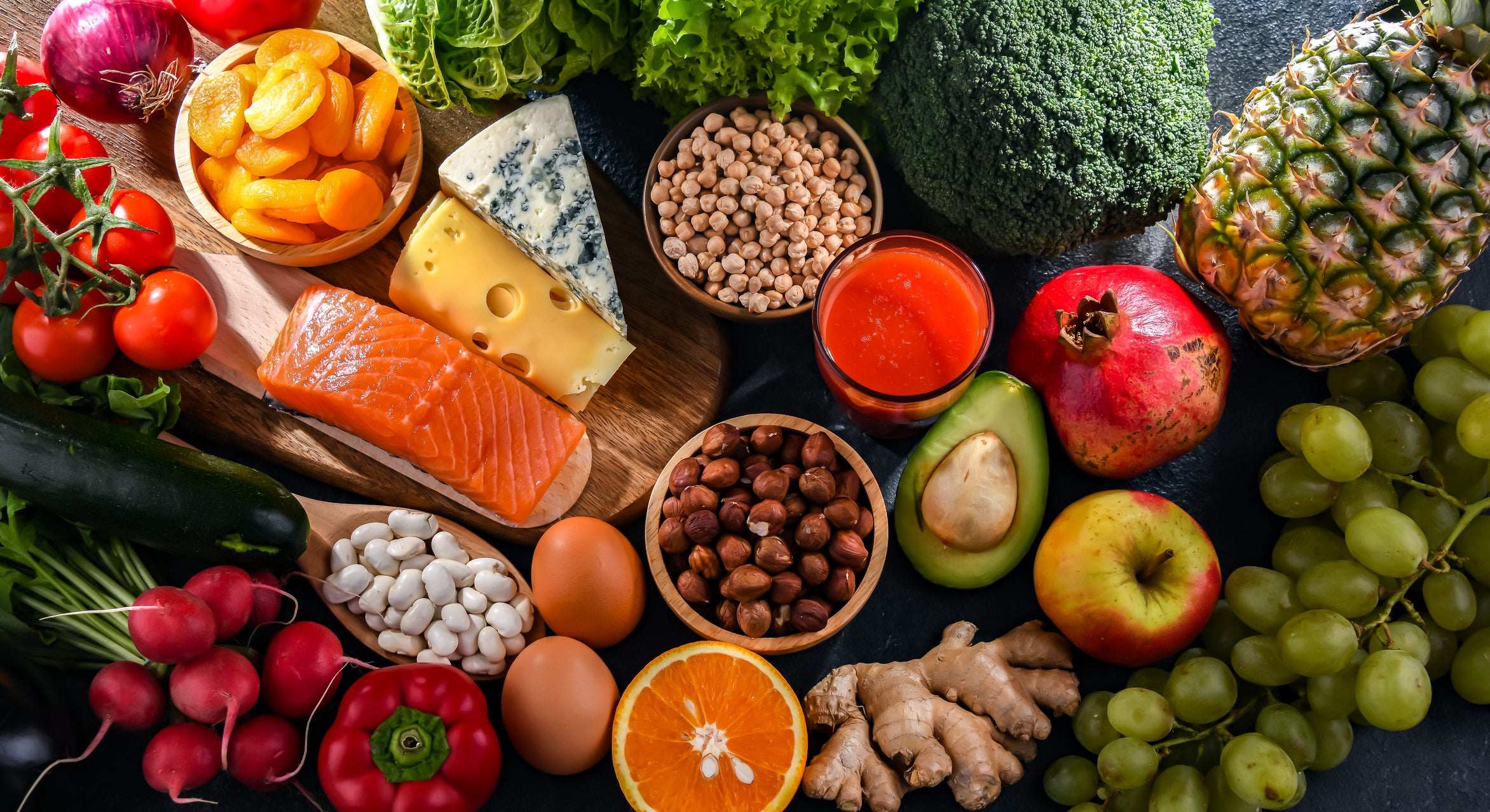 Top view of healthy food such as fruits, vegetables, whole grains, beans, and fish.