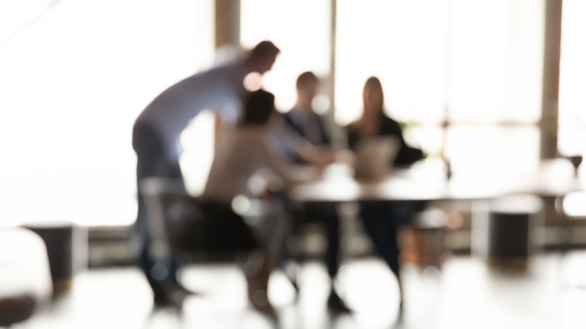 Blurry view of people working in an office.