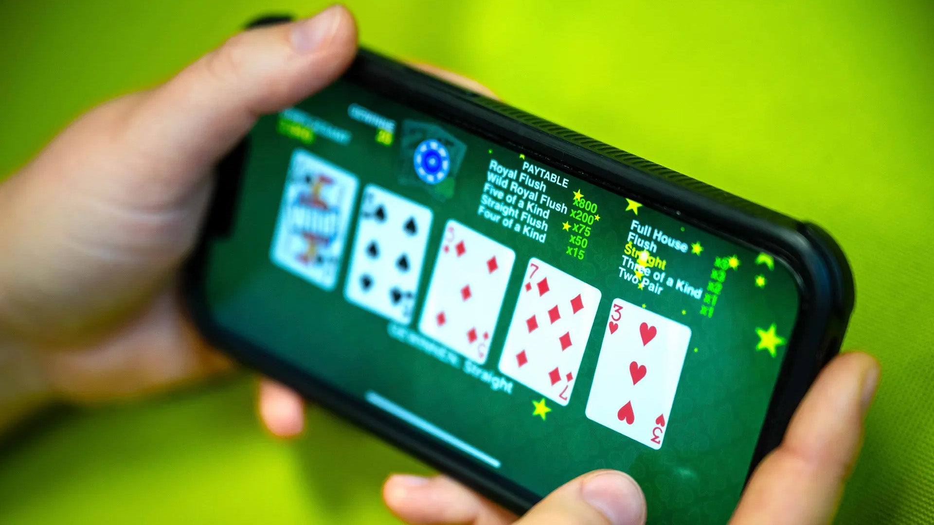 Close-up of person playing online poker on smartphone