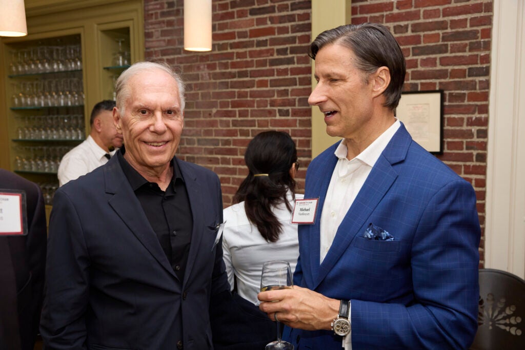 Two guests are engaged in conversation. One has noticed and smiled for the camera. 