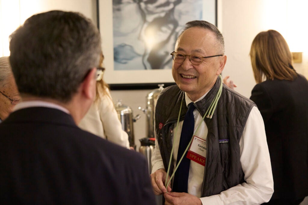 Gerald Chan leans forward to greet an attendee