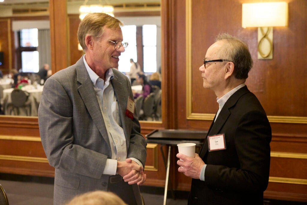 Two attendees converse in the conference room