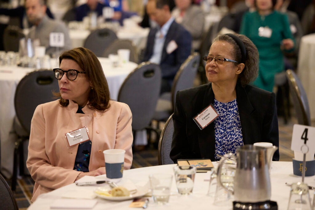 Two members listen thoughtfully to the program. 