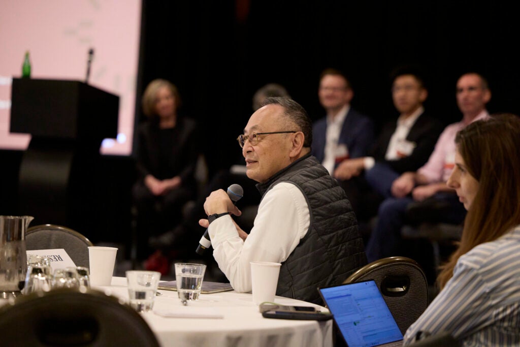 Gerald Chan asks a question from his table seat. 