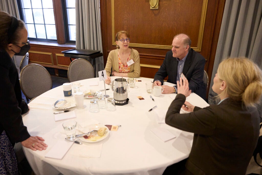 A woman speaks to a half-full table. 