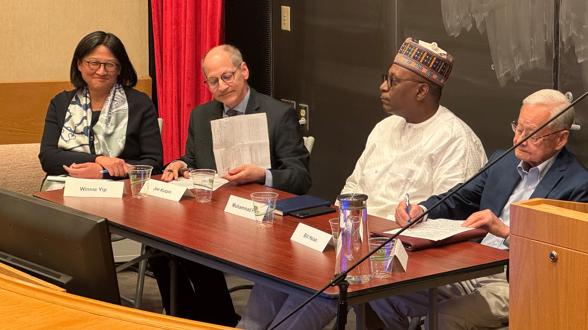 Winnie Yip, Joe Kutzin, Muhammad Pate, and Bill Hsiao sitting behind a table.